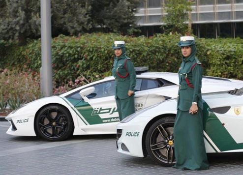Dubai policewomen pictured with two vehicles in the force's supercar fleet.