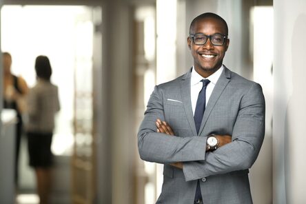 Handsome cheerful african american executive business man at the workspace office.jpg